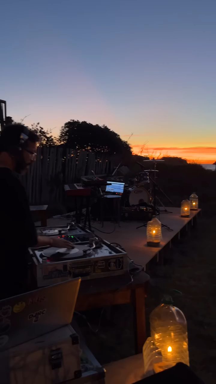 DJ tocando al atardecer frente al mar