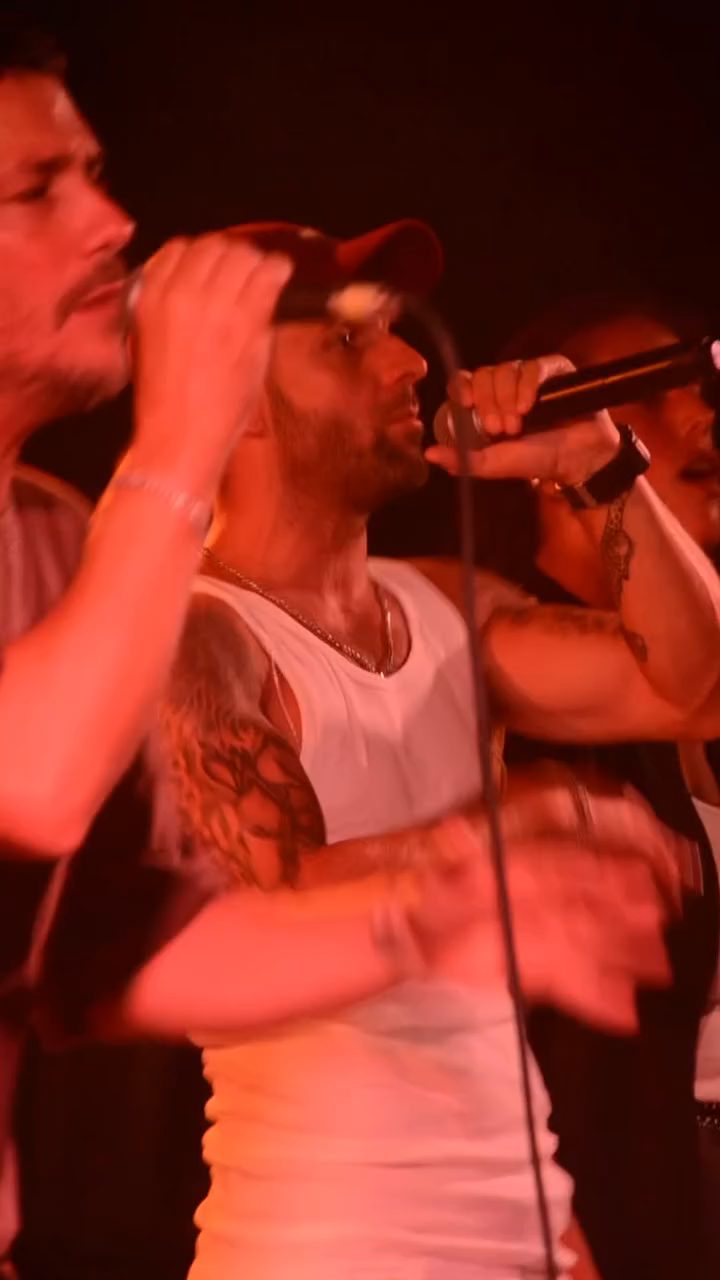 Músico cantando en vivo bajo luces rojas