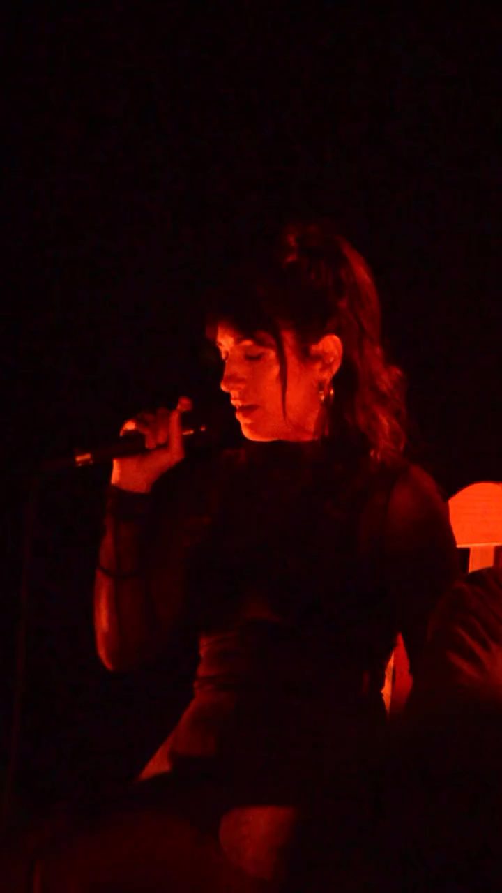 Cantante iluminada en rojo durante un show nocturno